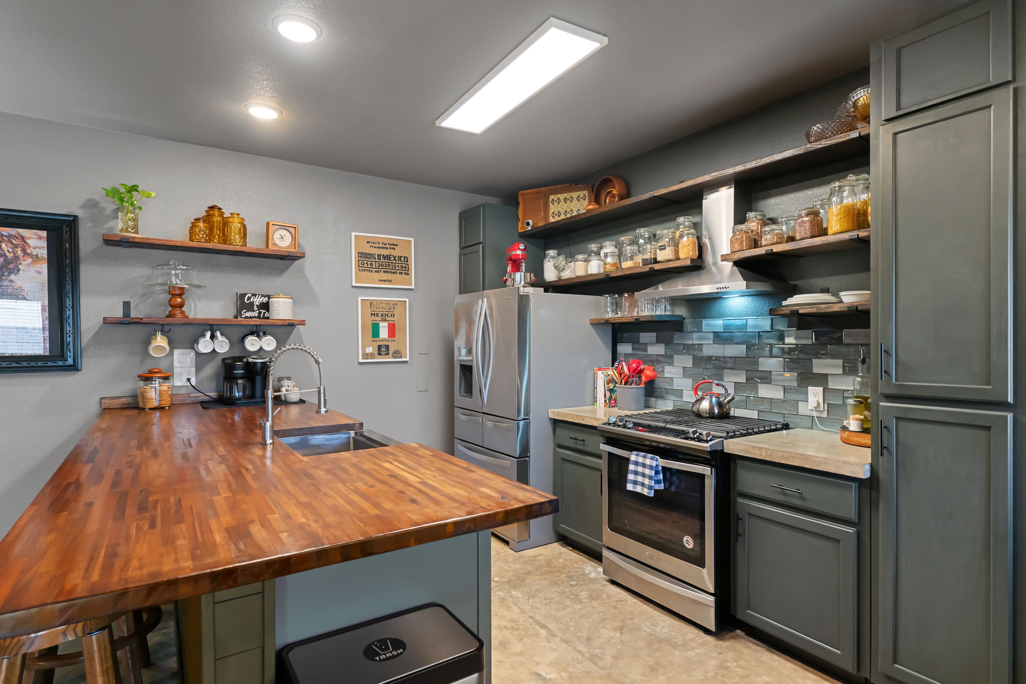 401 Kates Way Hutto, TX 78634 - Photo 10 of 37 Kitchen featuring open shelves, stainless steel appliances, butcher block counters, backsplash, and a breakfast bar