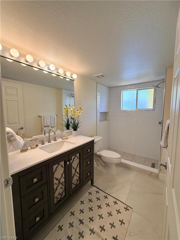 8274 Key Royal Circle, Unit 1012 Naples, FL 34119 - Photo 15 of 20 a spacious bathroom with a double vanity sink a toilet and a mirror