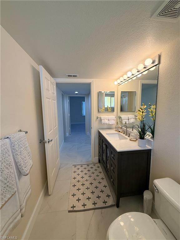 8274 Key Royal Circle, Unit 1012 Naples, FL 34119 - Photo 16 of 20 a spacious bathroom with a double vanity sink toilet and shower
