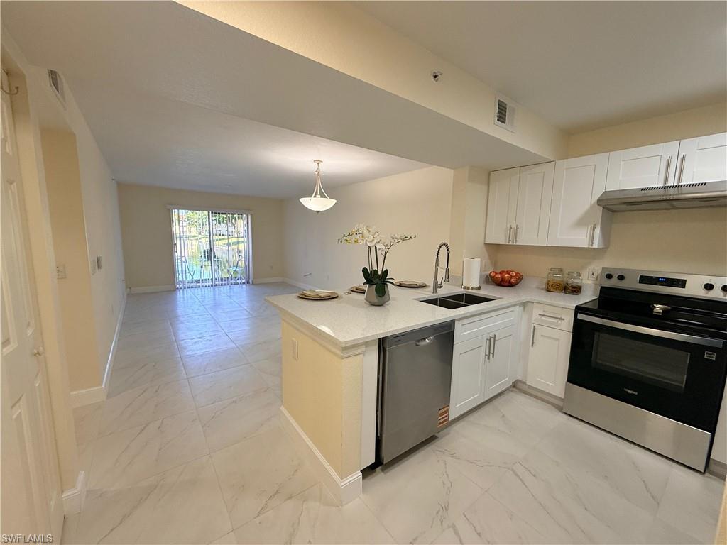 8274 Key Royal Circle, Unit 1012 Naples, FL 34119 - Photo 2 of 20 a kitchen with granite countertop a sink and a stove top oven