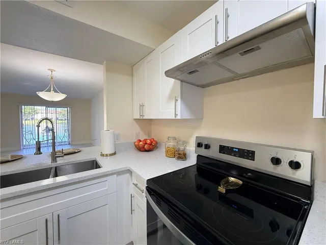 a kitchen with a stove a sink and cabinets