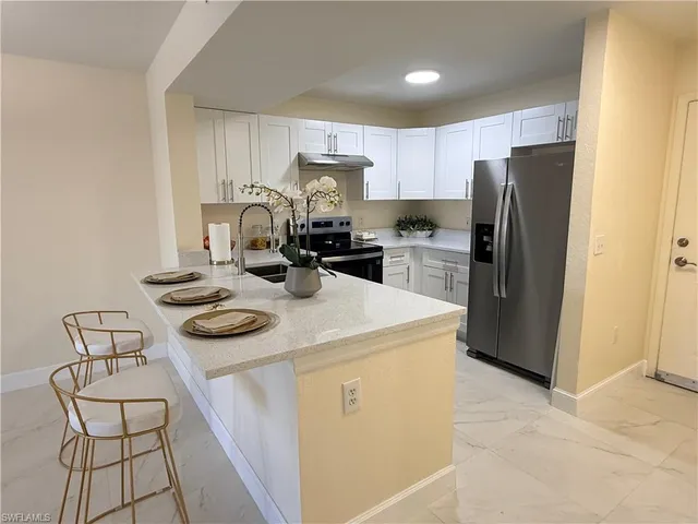 a kitchen with refrigerator a stove a sink and cabinets