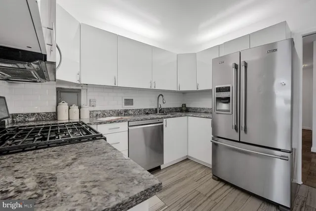 a kitchen with a refrigerator stove and white cabinets