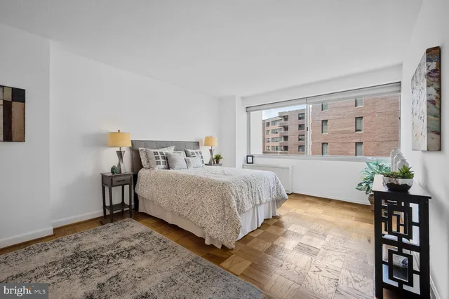 a bedroom with a bed table and a large mirror