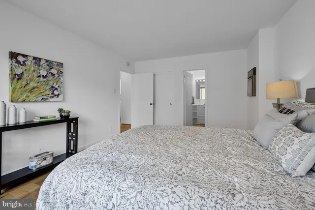 a bedroom with a bed and a lamp on dresser