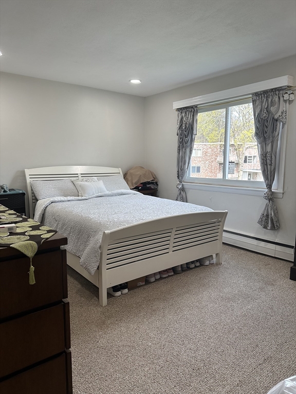 6 Jacqueline Road, Unit F Waltham, MA 02452 - Photo 7 of 14 a bed sitting in a room next to a window