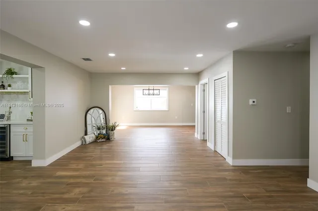 a view of empty room with window and wooden floor