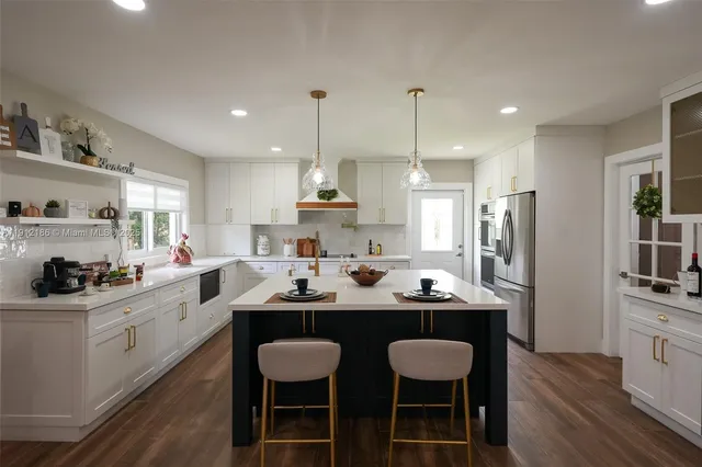 a kitchen with a dining table chairs sink and stove