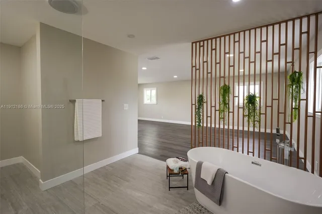 a view of an empty room with wooden floor and window