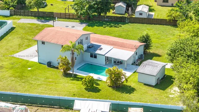 an aerial view of a house with a garden and swimming pool