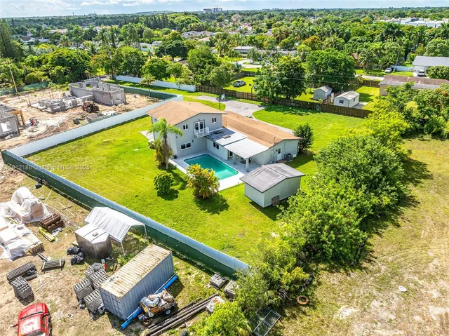 an aerial view of a house with a swimming pool yard and outdoor seating