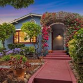 a front view of a house with a yard and potted plants