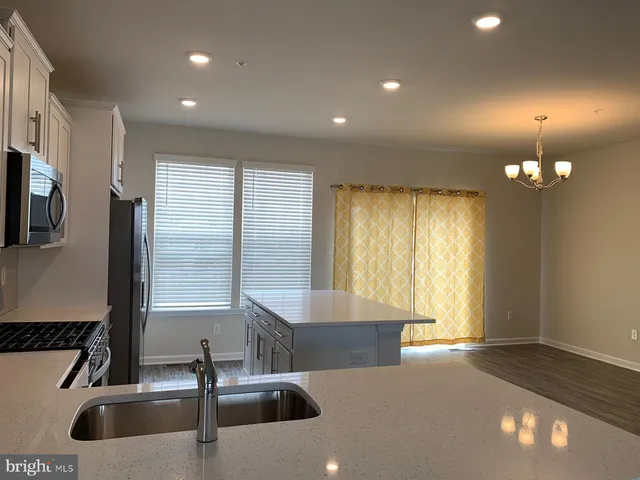 a kitchen with counter top a sink and a window