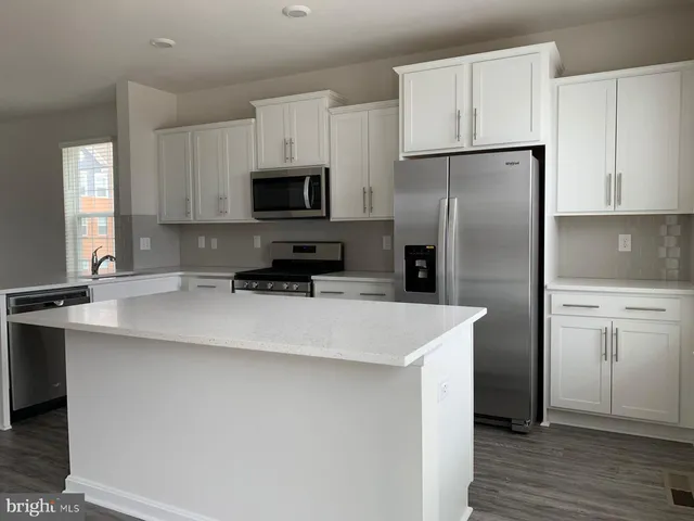 a kitchen with appliances a sink and a refrigerator
