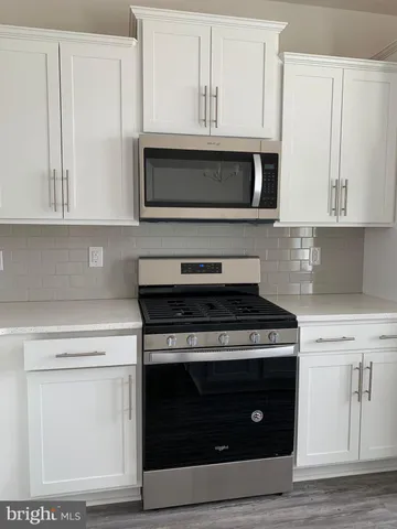 a kitchen with stainless steel appliances granite countertop a stove microwave and sink