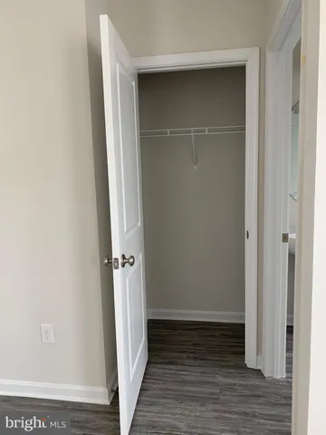 an empty room with wooden floor and entrance