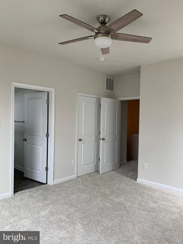 a view of an empty room and a ceiling fan