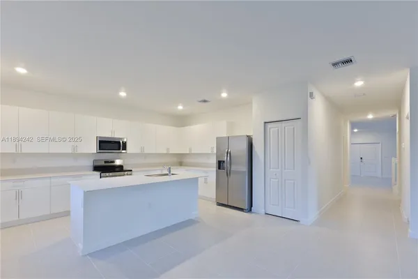 a kitchen with stainless steel appliances a refrigerator and a stove top oven