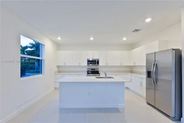 a kitchen with stainless steel appliances a sink and a refrigerator