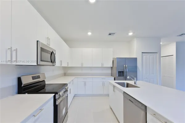 a kitchen that has a sink and a stove in it