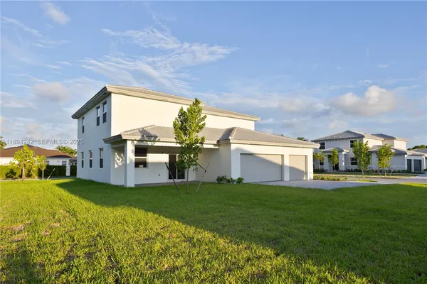 a view of a house with a big yard and large trees