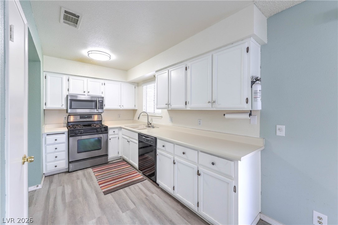 581 Carleton Drive Henderson, NV 89014 - Photo 10 of 37 A well-lit kitchen with sleek stainless steel appliances and abundant white cabinetry.