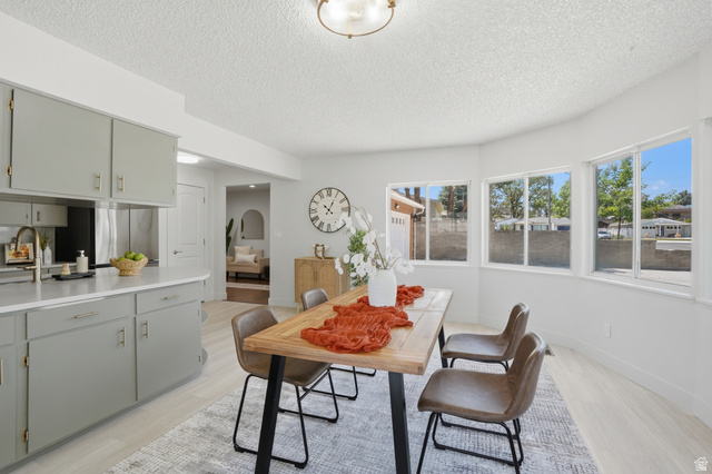 6889 South Village Road Salt Lake City, UT 84121 - Photo 10 of 44 Bright dining area with large bay windows, light LVP Tile flooring, and a modern ceiling fixture
