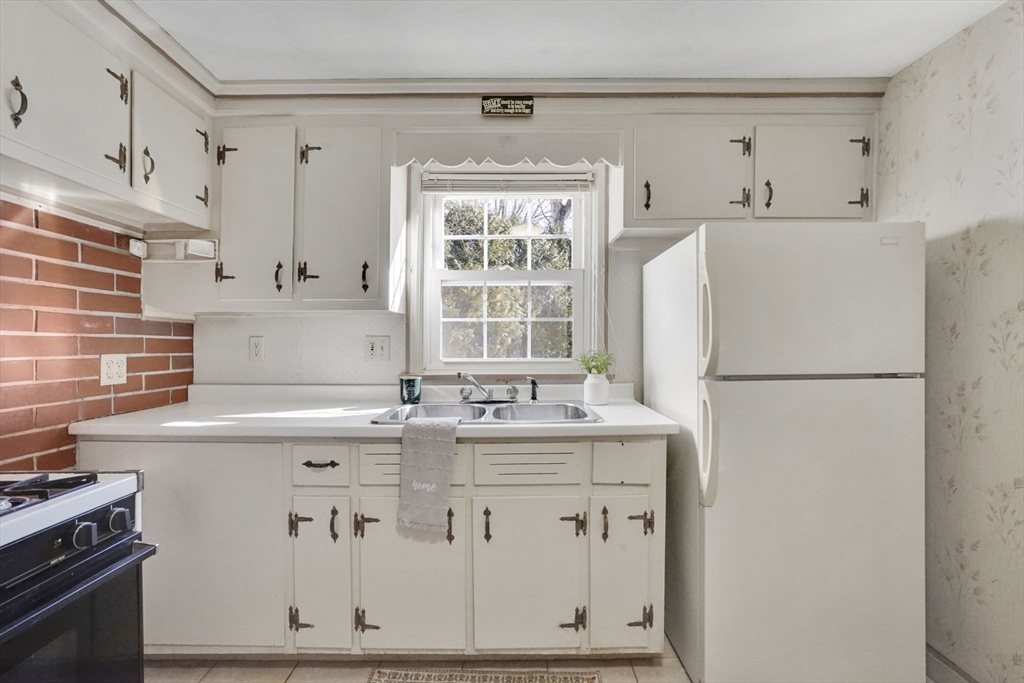 865 South Branch Parkway Springfield, MA 01118 - Photo 13 of 35 a kitchen with stainless steel appliances a refrigerator a sink and white cabinets