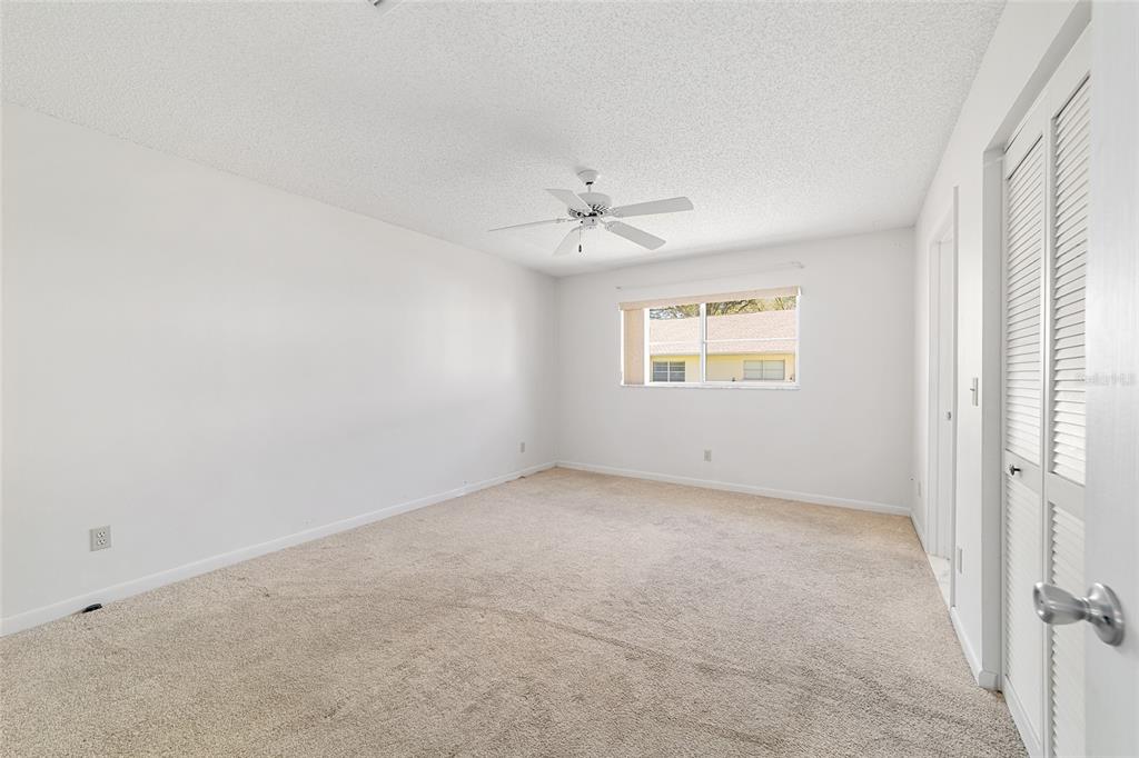 9460 Southwest 84th Terrace, Unit E Ocala, FL 34481 - Photo 13 of 21 an empty room with a window and a ceiling fan