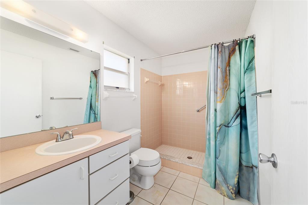 9460 Southwest 84th Terrace, Unit E Ocala, FL 34481 - Photo 14 of 21 a bathroom with a granite countertop sink a toilet and shower