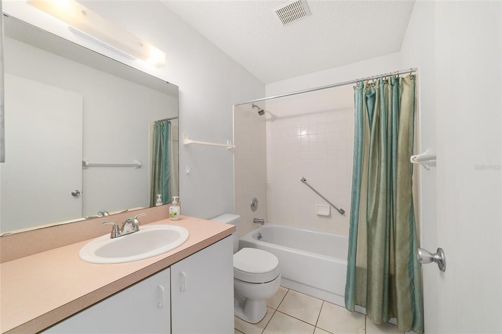 9460 Southwest 84th Terrace, Unit E Ocala, FL 34481 - Photo 16 of 21 a bathroom with a granite countertop sink toilet and shower