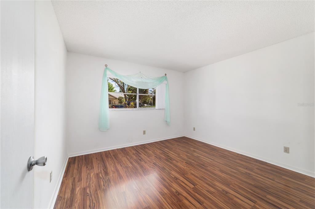 9460 Southwest 84th Terrace, Unit E Ocala, FL 34481 - Photo 17 of 21 an empty room with wooden floor and windows