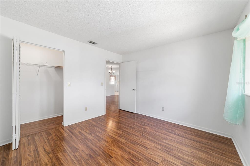 9460 Southwest 84th Terrace, Unit E Ocala, FL 34481 - Photo 18 of 21 a view of an empty room with wooden floor and a window