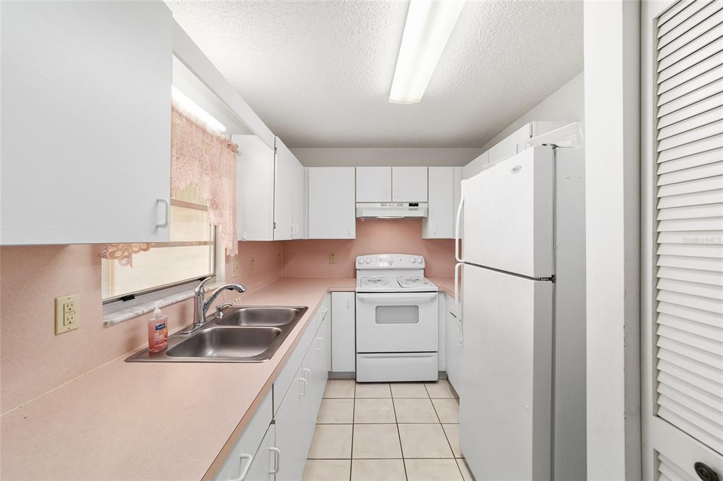 9460 Southwest 84th Terrace, Unit E Ocala, FL 34481 - Photo 9 of 21 a kitchen with a sink a refrigerator and cabinets
