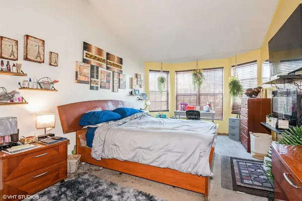 a bedroom with a bed a dresser next to a window