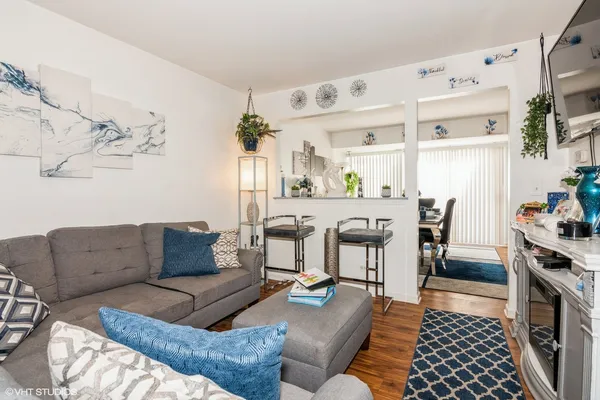 a living room with furniture and a dining table with wooden floor