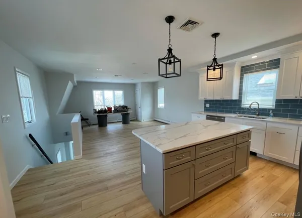a kitchen with a sink dishwasher a stove and a wooden floors