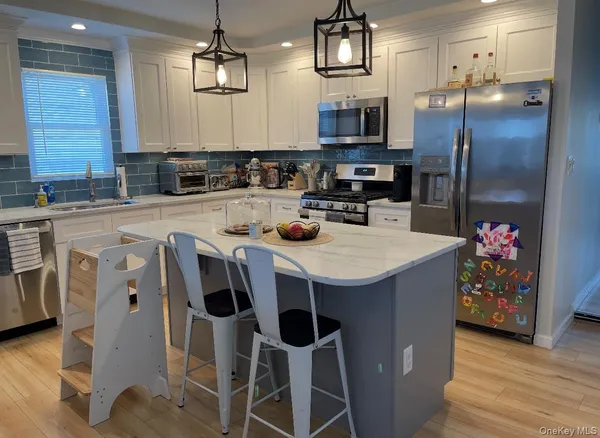 a kitchen with stainless steel appliances a sink a stove a refrigerator and cabinets