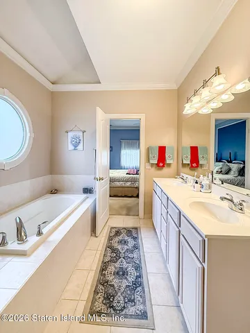 a large bathroom with a double vanity sink a mirror and a bathtub