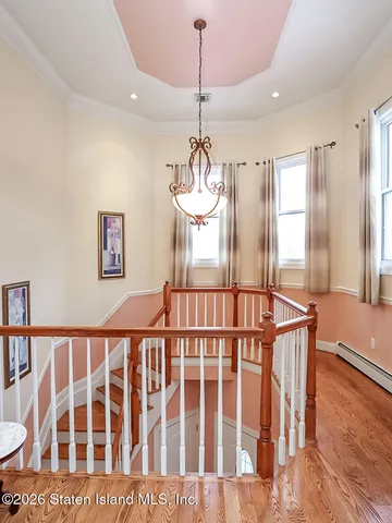 a dining room with wooden floor windows and a chandelier
