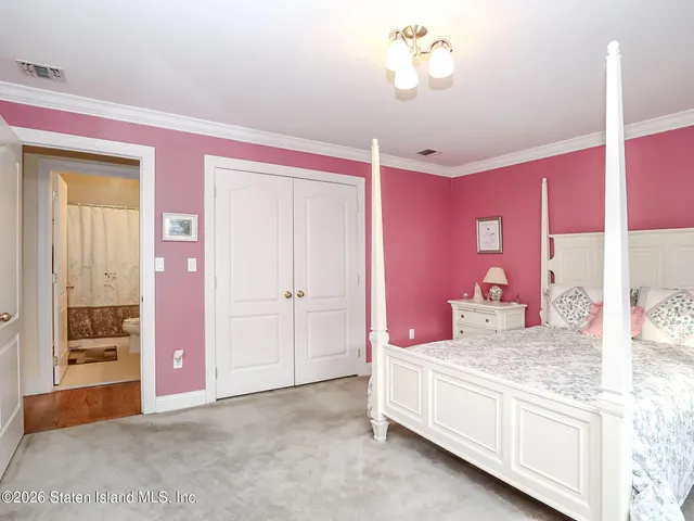 a spacious bedroom with a bed and a chandelier