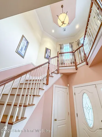a view of staircase with lots of frames on wall and a chandelier