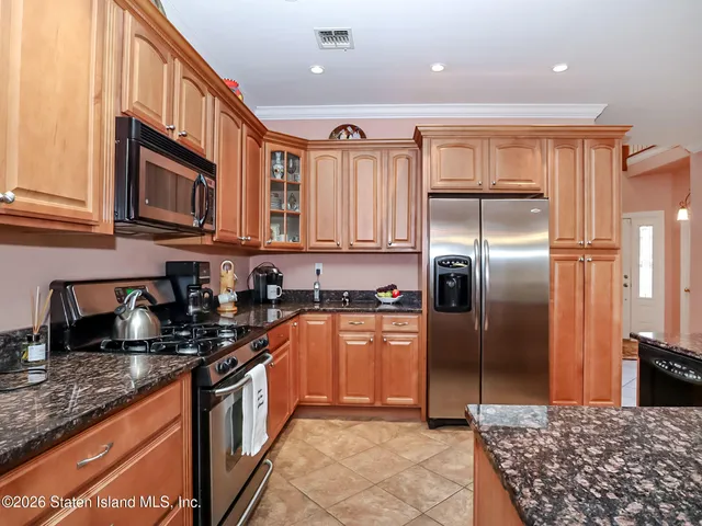 a kitchen with stainless steel appliances granite countertop a stove a sink and a refrigerator