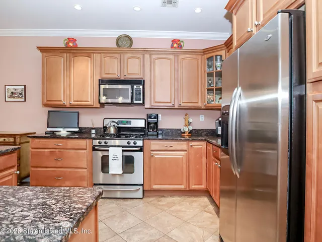 a kitchen with stainless steel appliances granite countertop a refrigerator sink and stove
