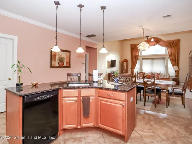 a kitchen with kitchen island granite countertop a sink a counter top space appliances and cabinets