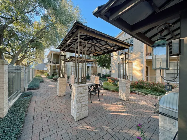 a view of a patio with table and chairs and a barbeque