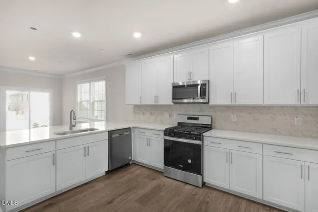 a kitchen with white cabinets and sink