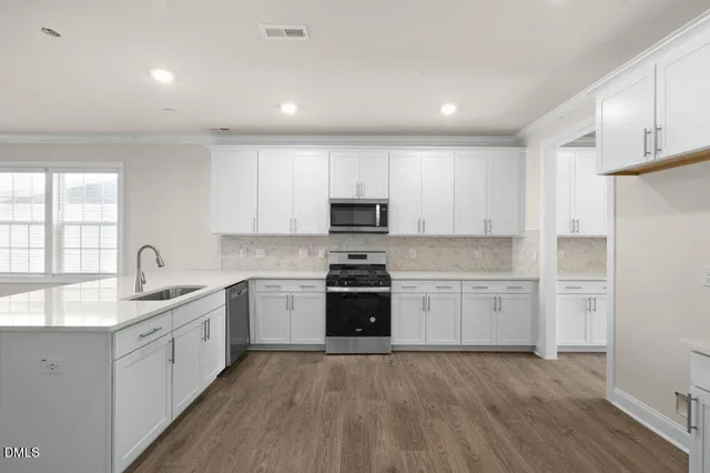 a kitchen with granite countertop white cabinets and white appliances