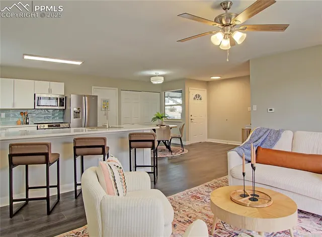 a living room with furniture and kitchen view