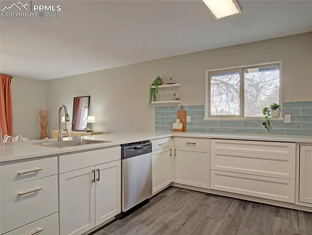 a kitchen with white cabinets and sink